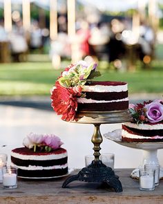 a table with three cakes and candles on it