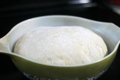 a bowl filled with dough sitting on top of a stove