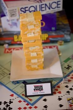 several pieces of cheese stacked on top of each other in front of some playing cards