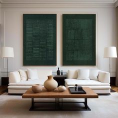 a living room filled with white furniture and two large green wall art pieces above the couches