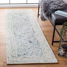 a large rug on the floor in a living room with a chair and window behind it