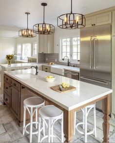 a large kitchen with an island and two stools