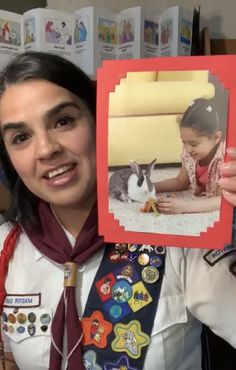 a woman holding up a photo with a rabbit on it