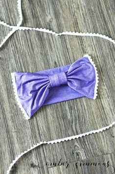 a purple bow tie laying on top of a wooden table