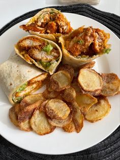 a white plate topped with three burritos and potato wedges