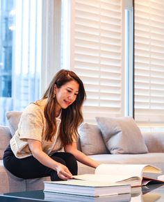 a woman sitting on the floor reading a book