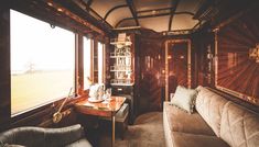 the inside of a train car with two couches and a table in front of it