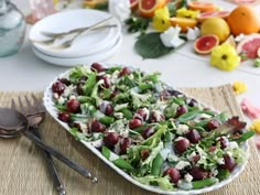 a salad with cranberries and lettuce is on a plate next to silverware