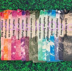 six tie dye socks with different sayings on them sitting in the middle of some grass