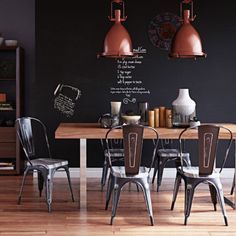 a dining room table and chairs in front of a chalkboard wall