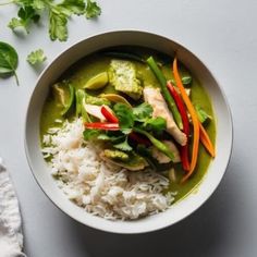 a bowl filled with rice and vegetables on top of a white table next to a napkin