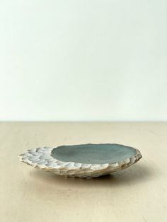 a white and gray plate sitting on top of a wooden table next to a wall