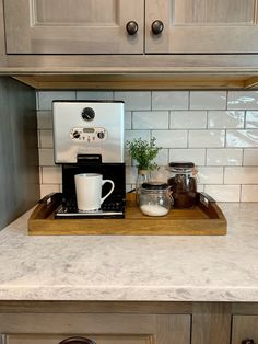 the coffee maker is sitting on top of the counter in the kitchen, and it's ready to be used