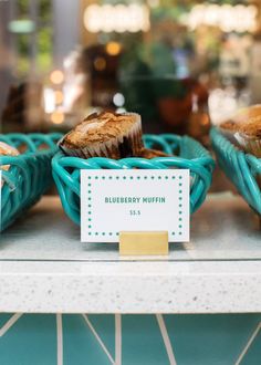 blueberry muffins on display in a bakery