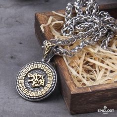 a wooden box with a silver chain and a necklace in it on top of a table