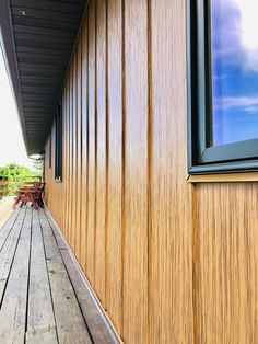 the side of a house with wood sidings and an open window on one side