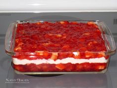 a casserole dish with strawberries and cream in it on top of the stove