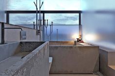 a bath room with a large window and a sink next to a wall mounted faucet