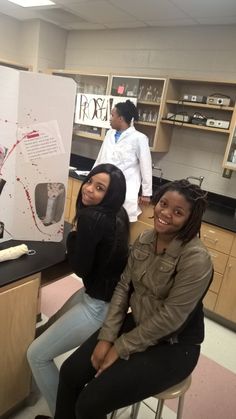 two women sitting at a counter in a lab