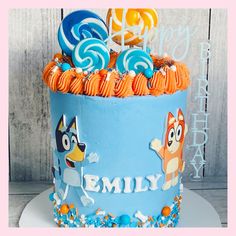 a birthday cake decorated with cartoon characters and lollipops