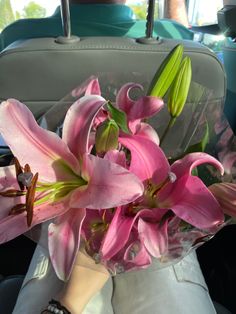 a bouquet of pink lilies in the back seat of a car