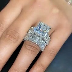 a woman's hand with two engagement rings on it