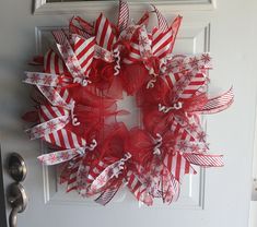 a red and white christmas wreath on the front door