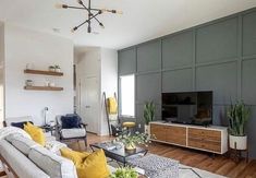 a living room filled with furniture and a flat screen tv mounted on a wall next to a wooden floor