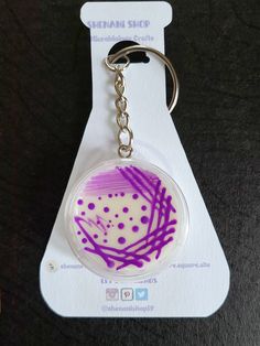 a keychain with a purple and white design on it