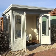 a small white shed with its doors open