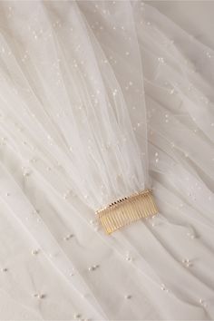 a hair comb laying on top of a white dress