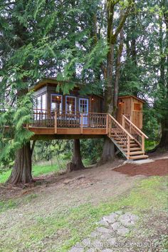 a tree house in the woods with stairs leading up to it's second story