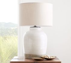 a white lamp sitting on top of a table next to a wooden box and bowl