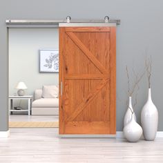 a living room with two vases and a barn door in the center is shown