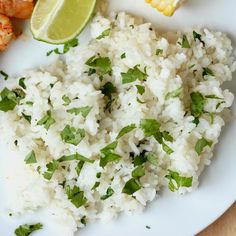 white rice with cilantro and corn on the cob, garnished with lime