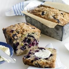 blueberry muffins with butter on top sitting next to a loaf of bread