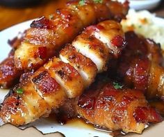 chicken wrapped in bacon on a plate with mashed potatoes