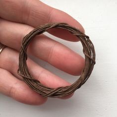 a hand holding a ring made out of twine