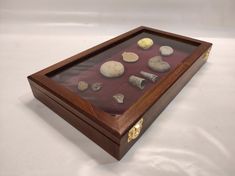 a wooden box with shells in it on a white surface