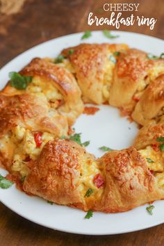 an egg and cheese breakfast ring on a white plate with parsley sprigs