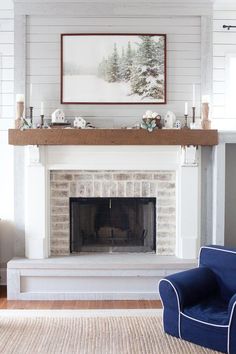 a living room with a white fireplace and blue chair