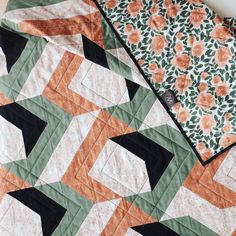 an orange and black quilt on top of a table