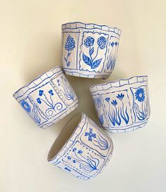 four blue and white bowls sitting on top of each other in the shape of flowers