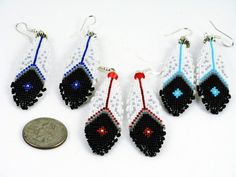 four beaded earrings with red, white and blue beads on them next to a penny