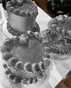 three silver cakes sitting on top of a table