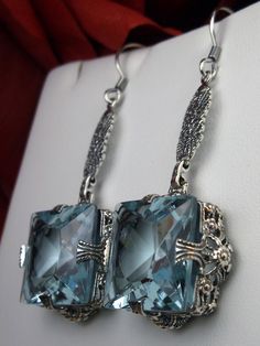 "Simulated Sky Blue Topaz Earrings Description MADE TO ORDER These are Victorian reproduction estate earrings in sterling silver set with flawless high quality Simulated blue topaz gemstones. Each stunning blue gemstone is 15mm long (9/16th\") and 15mm wide. The earrings are 2 inches long. Notice the beautiful floral setting. These lovely earrings were designed from an antique Victorian floral ring. A gift box is included and all items are shipped in the box for safe keeping. Feel free to ask qu Antique Rings Victorian, Floral Filigree, Order Design, Aquamarine Earrings, Blue Topaz Earrings, Victorian Rings, Filigree Earrings, Sterling Silver Filigree, Topaz Earrings