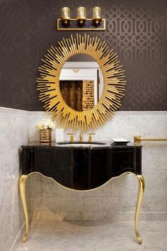 a black and gold console table with a mirror on the wall next to it in a bathroom