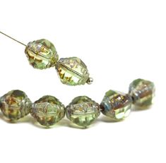 green glass bead necklace on white background with spacer for beads to hold them