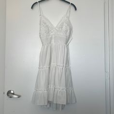 White Flowy Babydoll Style Dress. Size Small. Ties In Back. New With Tags. 100% Polyester. White Fitted Sundress With Lace Trim, White Lace Trim Fitted Sundress, Cute White Lace Mini Dress, Cute White V-neck Sundress, White Cotton Sundress With Lace Trim, White Lace Sundress With Spaghetti Straps, Cute White Sundress For Daywear, White Lace Trim Sundress, White Lace Daytime Dress