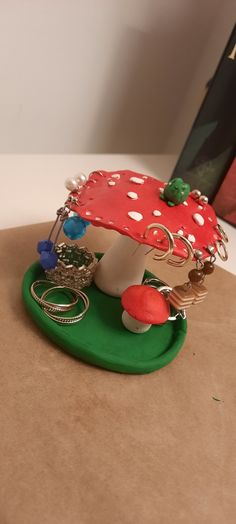 a red and white mushroom sitting on top of a green plate next to a book